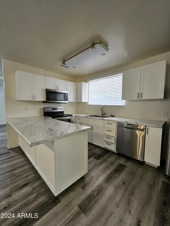 a kitchen with stainless steel appliances granite countertop a stove a sink and a microwave