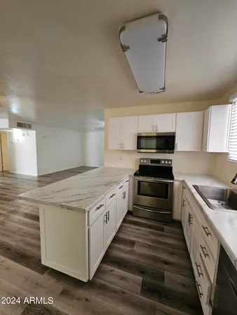 a large kitchen with cabinets stove and sink