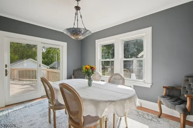 a dining room with furniture a chandelier and wooden floor