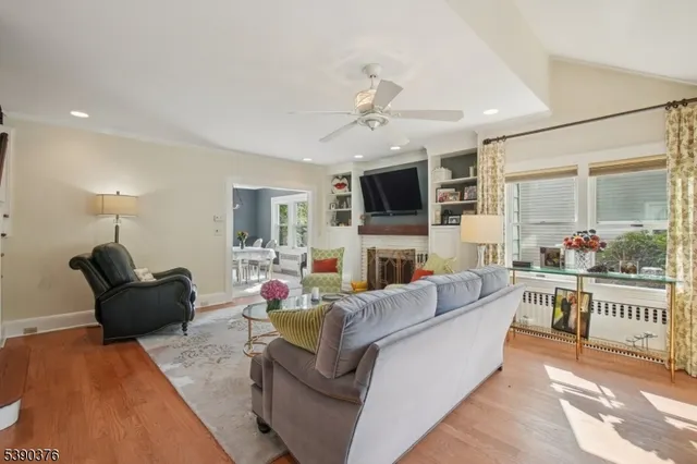a living room with furniture a flat screen tv and a chandelier