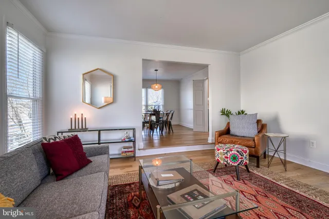 a view of a dining room and livingroom with furniture wooden floor a chandelier