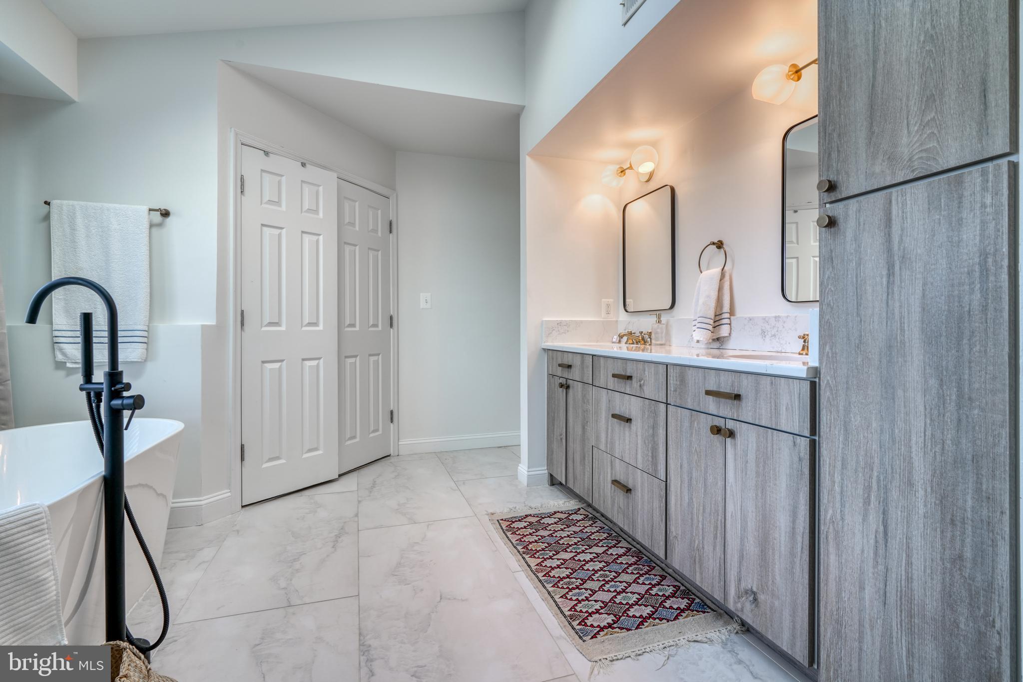 14235 Masterpiece Lane North Potomac, MD 20878 - Photo 42 of 66 a bathroom with a double vanity sink a mirror and a shower