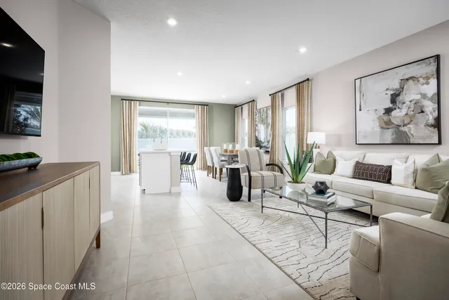 a living room with furniture a flat screen tv and a large window