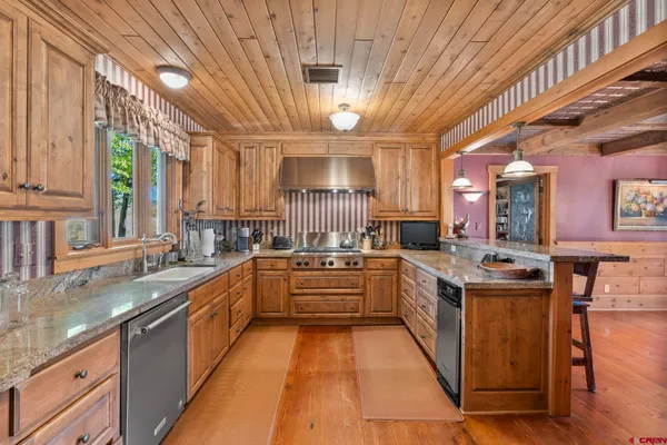 a room with stainless steel appliances kitchen island granite countertop furniture and a kitchen view