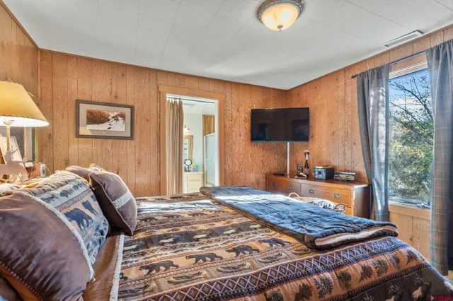 a bedroom with a bed and a large window