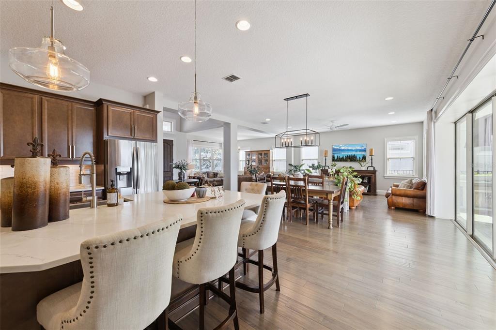 13436 Heswall Run Orlando, FL 32832 - Photo 11 of 72 a dining room with stainless steel appliances kitchen island granite countertop a table chairs and a refrigerator
