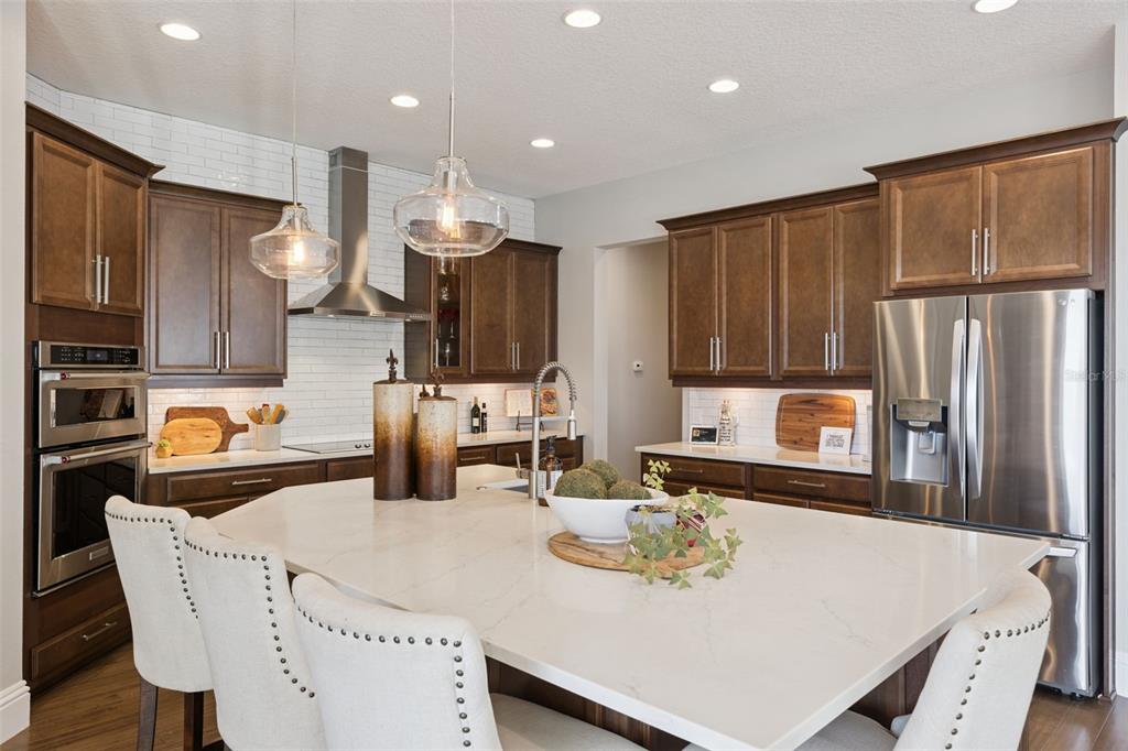 13436 Heswall Run Orlando, FL 32832 - Photo 13 of 72 a kitchen with granite countertop a table chairs microwave and refrigerator