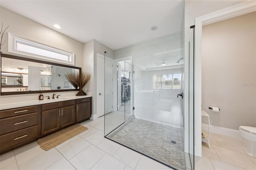 13436 Heswall Run Orlando, FL 32832 - Photo 17 of 72 a large bathroom with a granite countertop sink mirror and shower