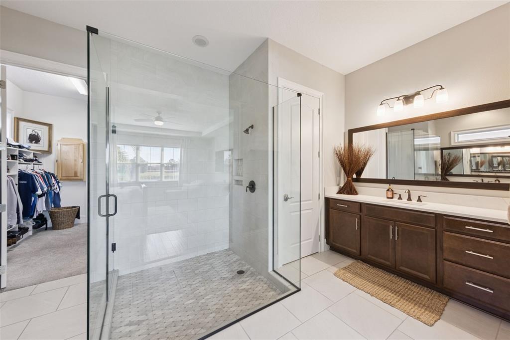 13436 Heswall Run Orlando, FL 32832 - Photo 18 of 72 a bathroom with a double vanity sink a large mirror and a shower