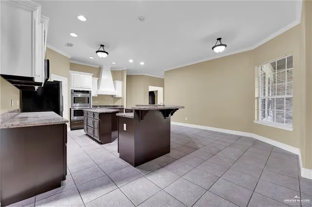 a large kitchen with stainless steel appliances granite countertop a large counter top and a stove top oven
