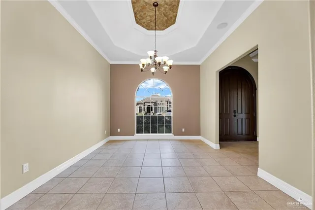 an empty room with windows and chandelier