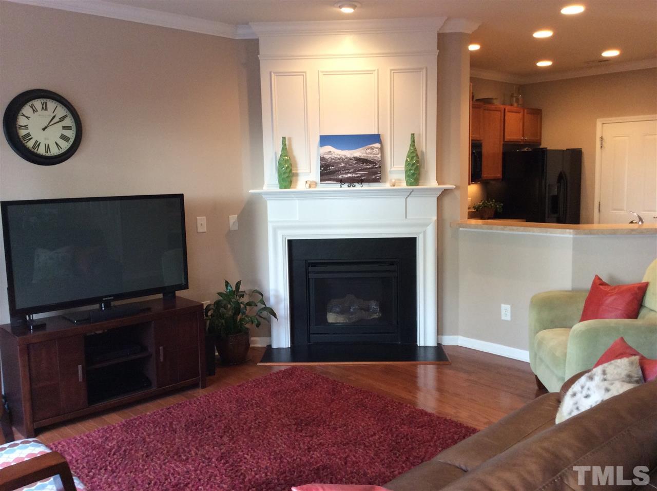 8706 Owl Roost Place Raleigh, NC 27617 - Photo 3 of 7 a living room with furniture a flat screen tv and a fireplace