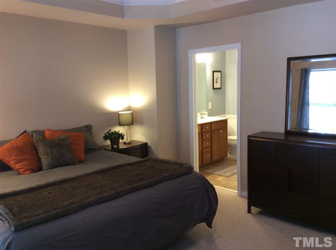 8706 Owl Roost Place Raleigh, NC 27617 - Photo 5 of 7 a bedroom with a bed and a lamp on dresser