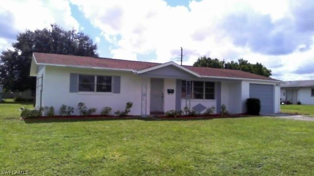 a front view of a house with a garden and yard