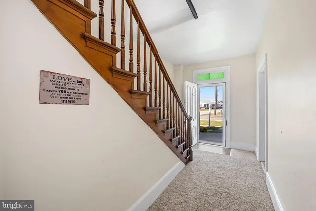 a view of staircase with wooden floor and white walls