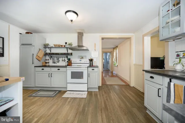 a kitchen with cabinets wooden floor and stainless steel appliances