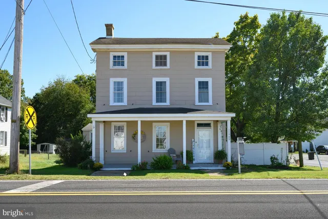 a front view of a house with a garden and plants