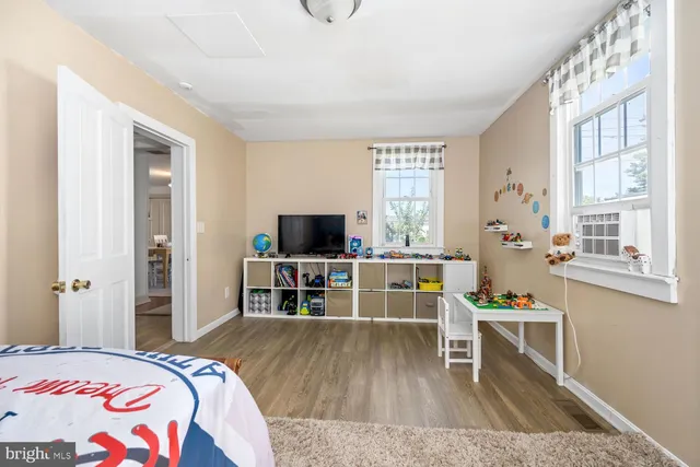 a bedroom with a bed and a flat tv screen on the dresser