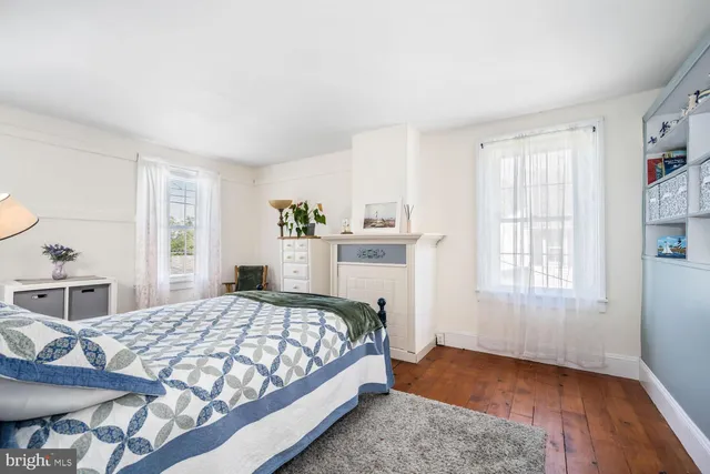 a bedroom with a bed and a table in it with window