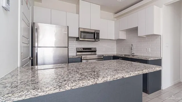 a kitchen with a refrigerator and a stove top oven