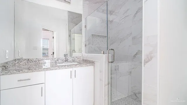 a bathroom with a granite countertop sink and a mirror