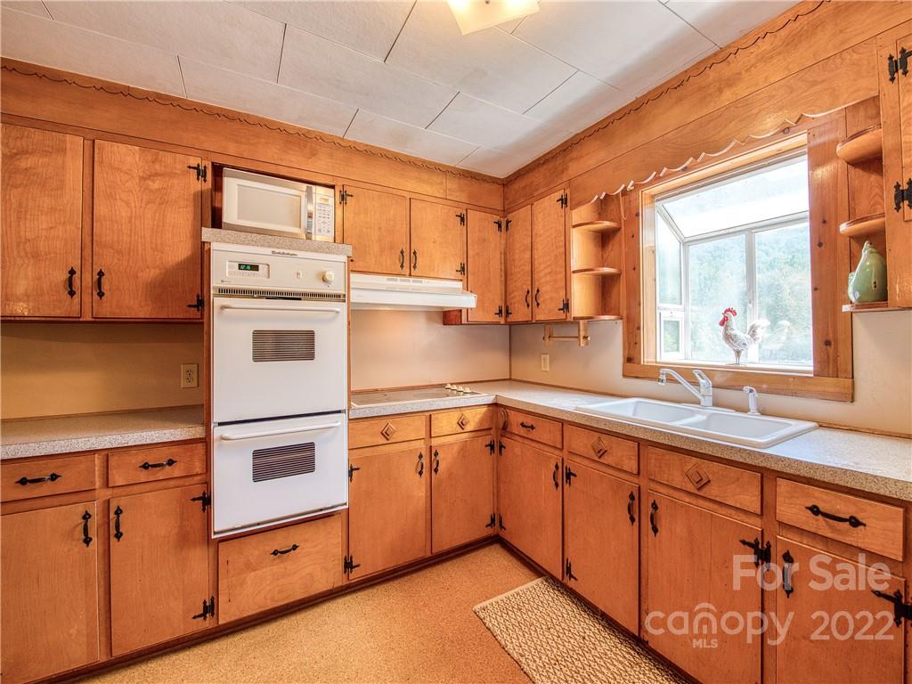 5474 Soco Road Maggie Valley, NC 28751 - Photo 11 of 48 a kitchen with stainless steel appliances granite countertop a sink and cabinets