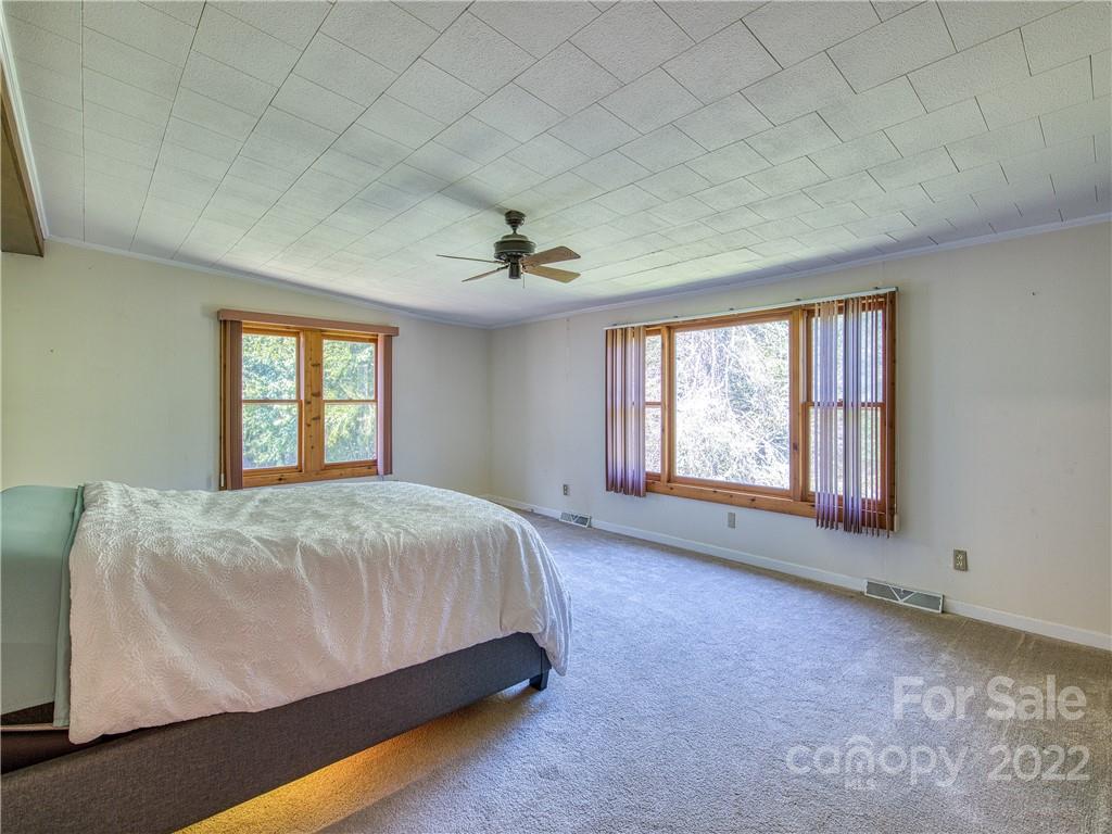 5474 Soco Road Maggie Valley, NC 28751 - Photo 17 of 48 a bed sitting in a spacious bedroom next to a window