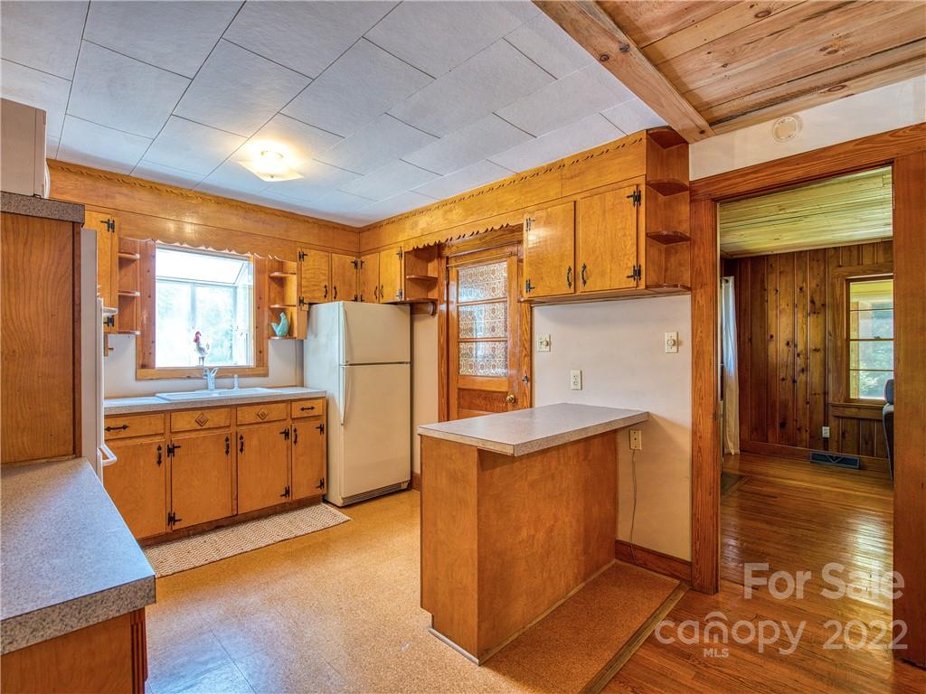5474 Soco Road Maggie Valley, NC 28751 - Photo 10 of 48 a kitchen with sink a refrigerator and wooden cabinets