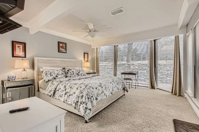 a bed sitting in a spacious bedroom next to a window