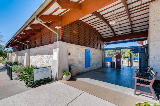 a view of swimming pool with lawn chairs and potted plants