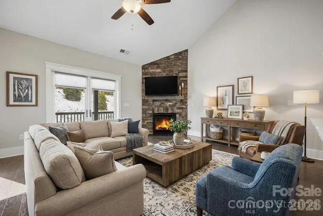 a living room with furniture kitchen view and a fireplace