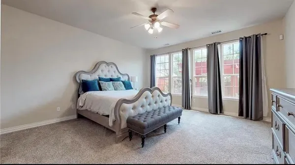 a bed sitting in a spacious bedroom next to a window