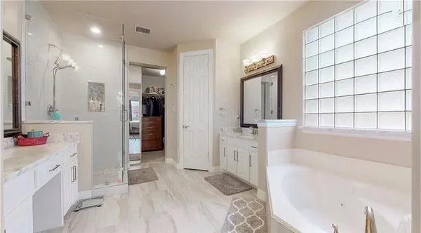 a bathroom with a tub sink and mirror