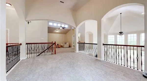 a view of staircase with railing and a chandelier