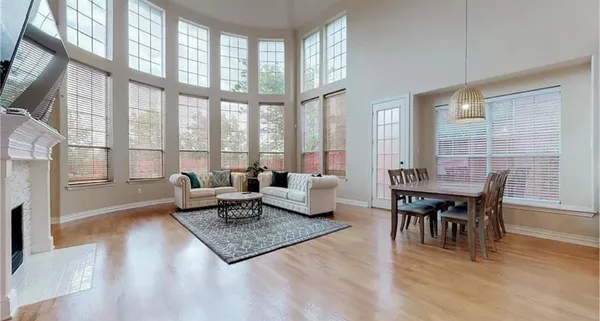 a living room with furniture a wooden floor and a large window