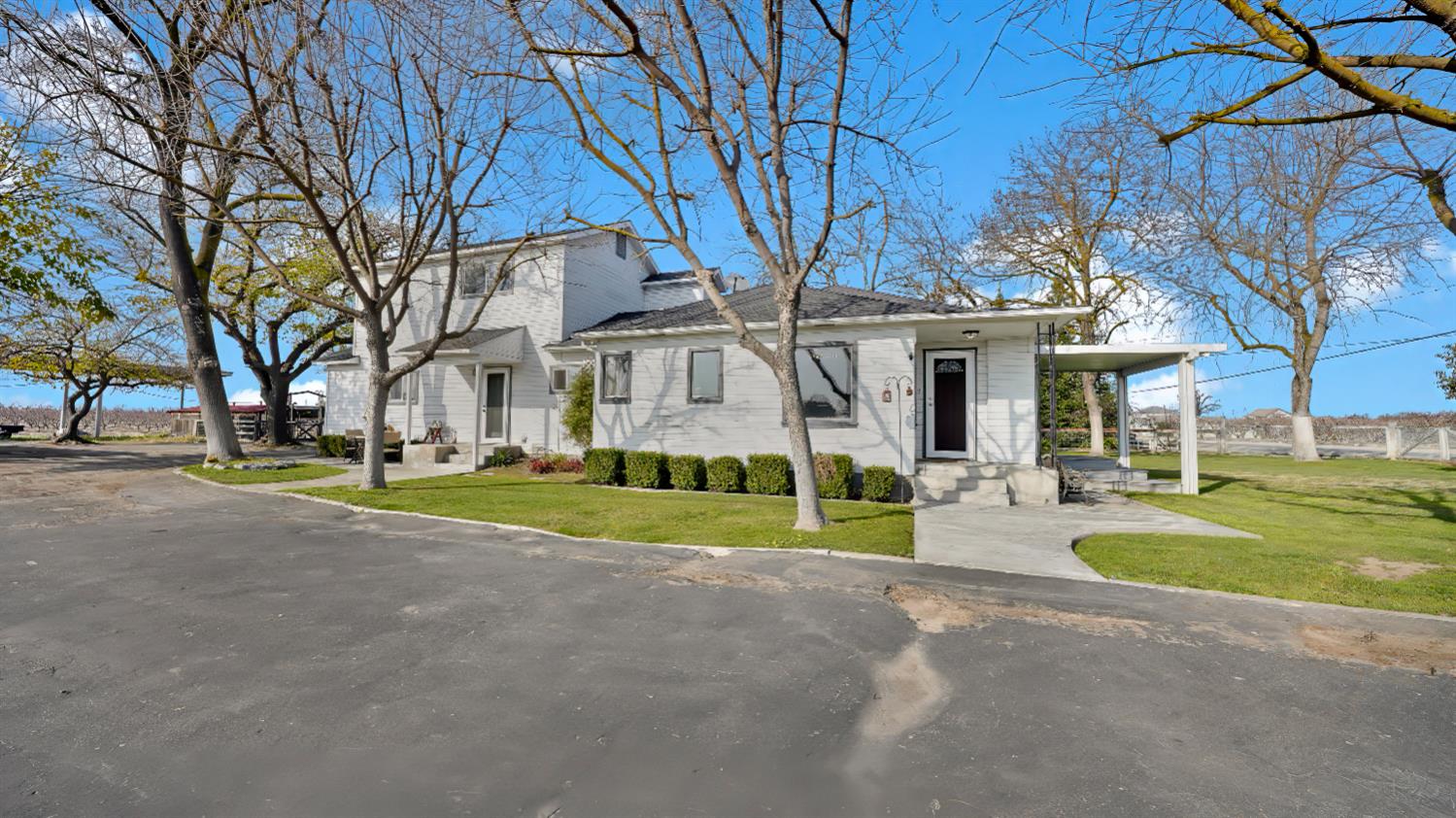 41709 Road 52 Reedley, CA 93654 - Photo 18 of 52 a view of a white house with a large tree and a yard