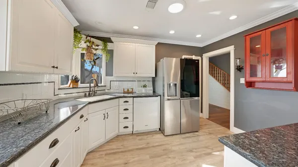 a large kitchen with stainless steel appliances granite countertop a refrigerator and a sink