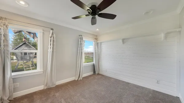 an empty room with fan and windows