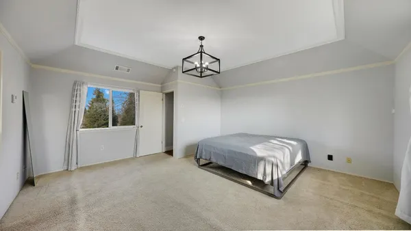 a spacious bedroom with a bed and window