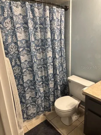 a white toilet sitting next to a shower curtain
