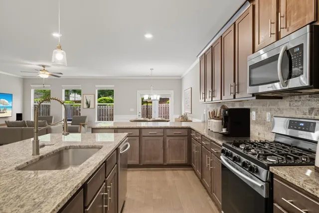 a kitchen with kitchen island granite countertop wooden cabinets and stainless steel appliances