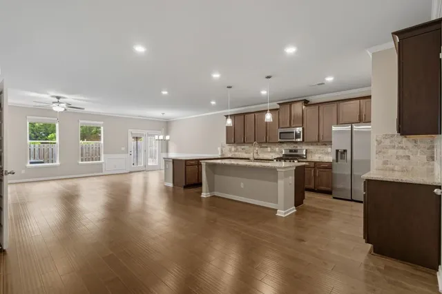 a kitchen with granite countertop kitchen island a sink appliances and a counter space