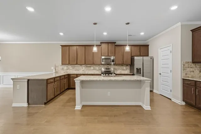 a kitchen with stainless steel appliances granite countertop a sink stove and microwave