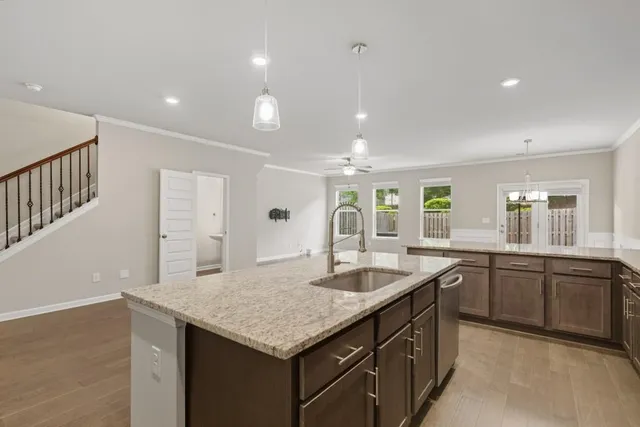 an empty room with wooden floor cabinet and windows