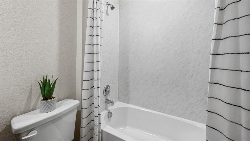 412 Wild Rose Way Princeton, TX 75407 - Photo 25 of 33 a bathroom with a toilet and a bathtub