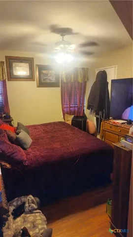 a bedroom with a bed and teddy bear on bed