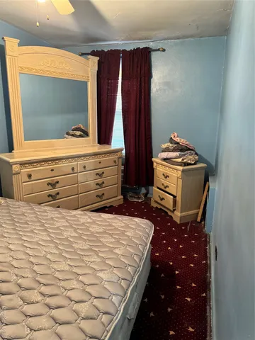 a bedroom with a bed and a mirror on the dresser