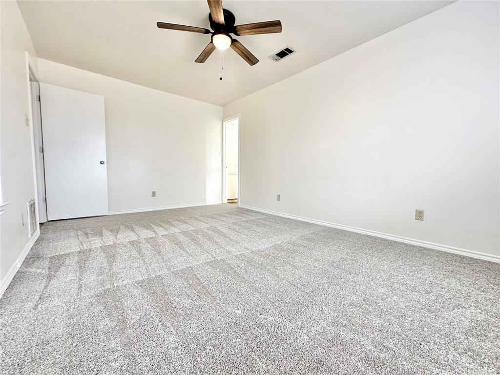 8869 Liberty Road Aubrey, TX 76227 - Photo 11 of 25 an empty room with a ceiling fan and window