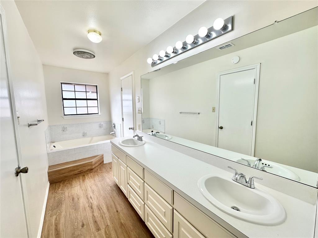 8869 Liberty Road Aubrey, TX 76227 - Photo 12 of 25 a bathroom with a tub sink and mirror