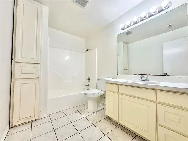 a bathroom with a double vanity sink a toilet and a mirror